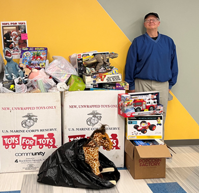 Russ posing with all the toys donated by KAM employees.